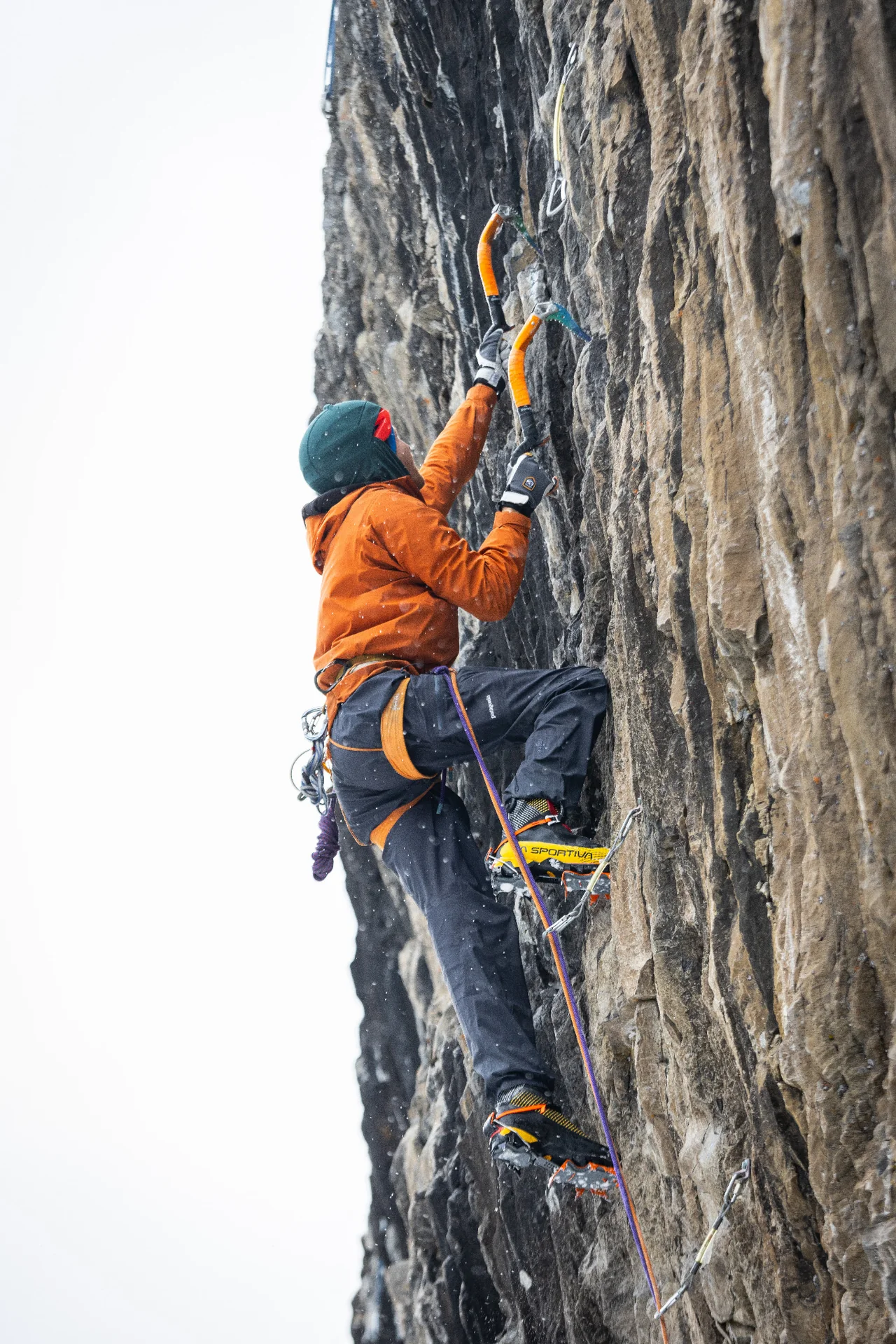 Michael O’Connell in orange using ice tools on the steep rock of Panama Canal.